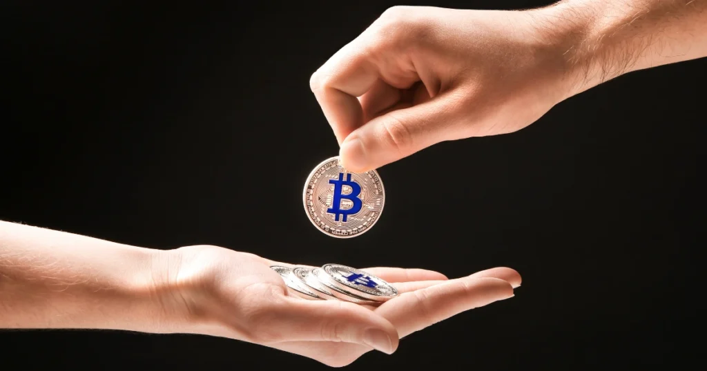 A hand passing a Bitcoin to another hand, symbolizing Bitcoin inheritance.